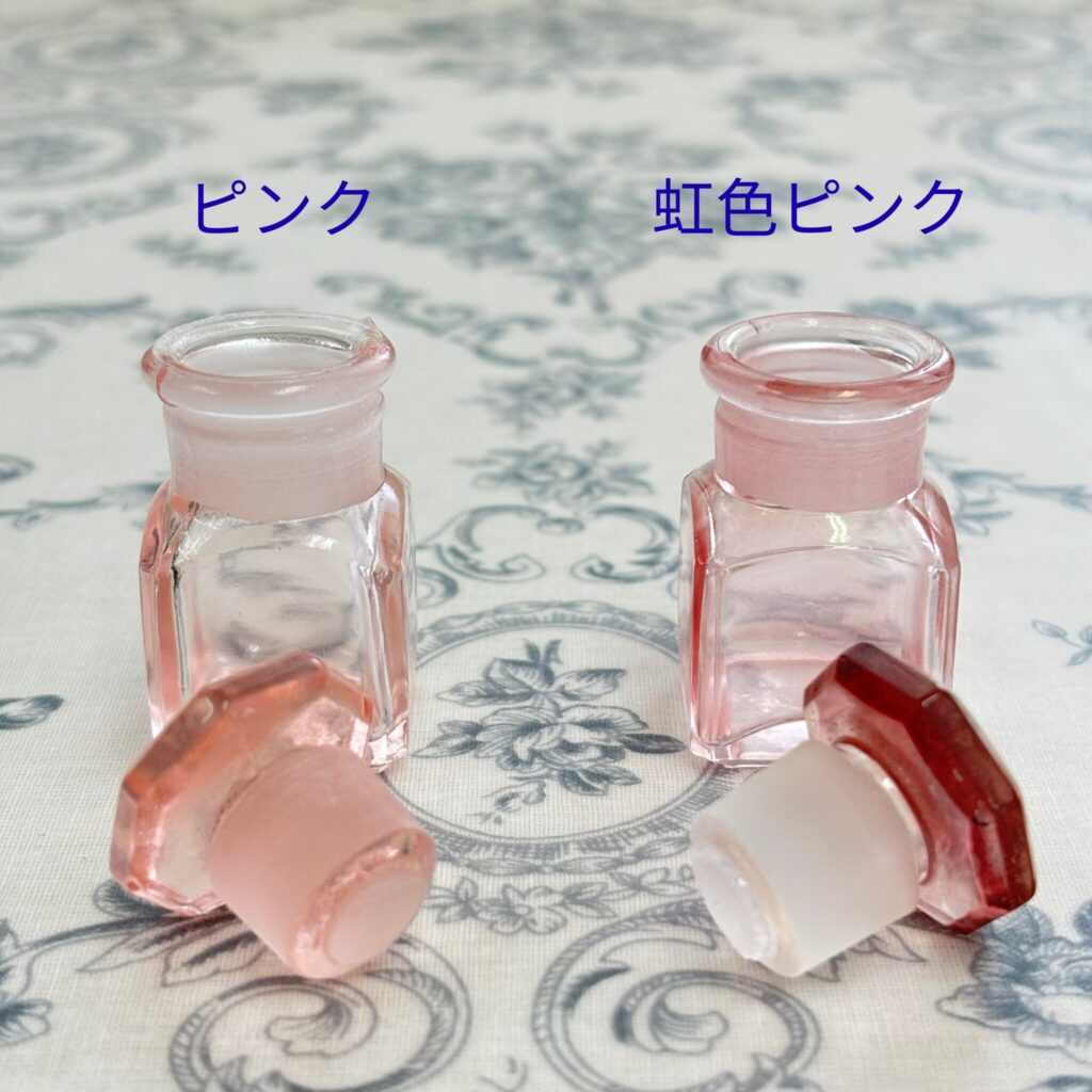 ピンク薬瓶と虹色ピンク薬瓶を並べて比較した写真。フタを外した状態も写っている。